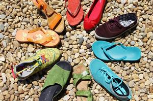 An array of brightly colored shoes in a circle with toes pointed toward the center